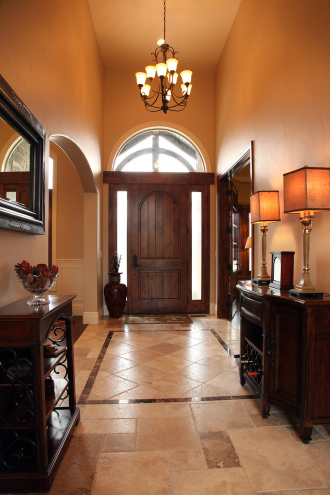 На фото: фойе среднего размера: освещение в классическом стиле с бежевыми стенами, полом из керамогранита, одностворчатой входной дверью и входной дверью из дерева среднего тона с