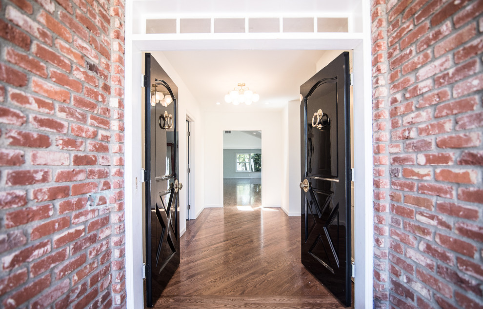 Photo of a medium sized classic foyer in Los Angeles with white walls, medium hardwood flooring, a double front door, a black front door and brown floors.