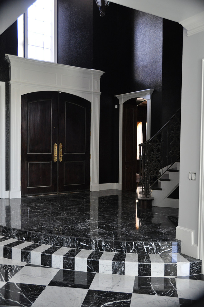 Immagine di un grande ingresso tradizionale con pareti nere, pavimento in marmo, una porta a due ante, una porta in legno scuro e pavimento multicolore