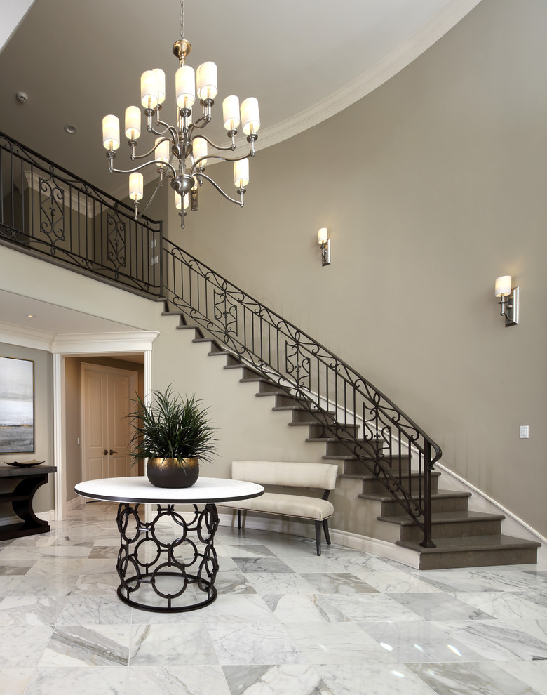 This is an example of a large classic foyer in San Francisco with beige walls and marble flooring.