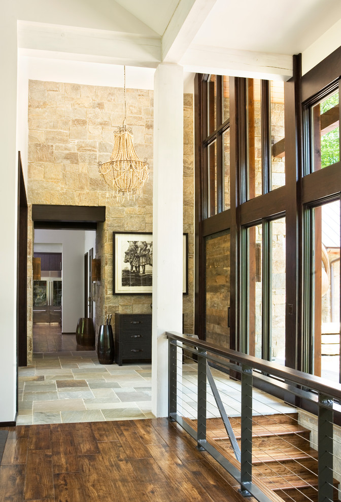 他の地域にあるラスティックスタイルのおしゃれな玄関ロビー (マルチカラーの壁、スレートの床、金属製ドア) の写真