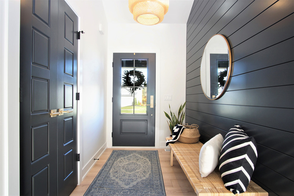 На фото: узкая прихожая среднего размера в скандинавском стиле с светлым паркетным полом, одностворчатой входной дверью, черной входной дверью, черными стенами и бежевым полом с