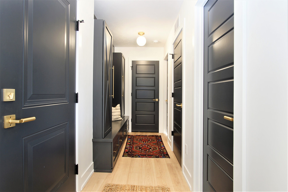 Medium sized scandi boot room in Grand Rapids with white walls, light hardwood flooring, beige floors, a single front door and a black front door.