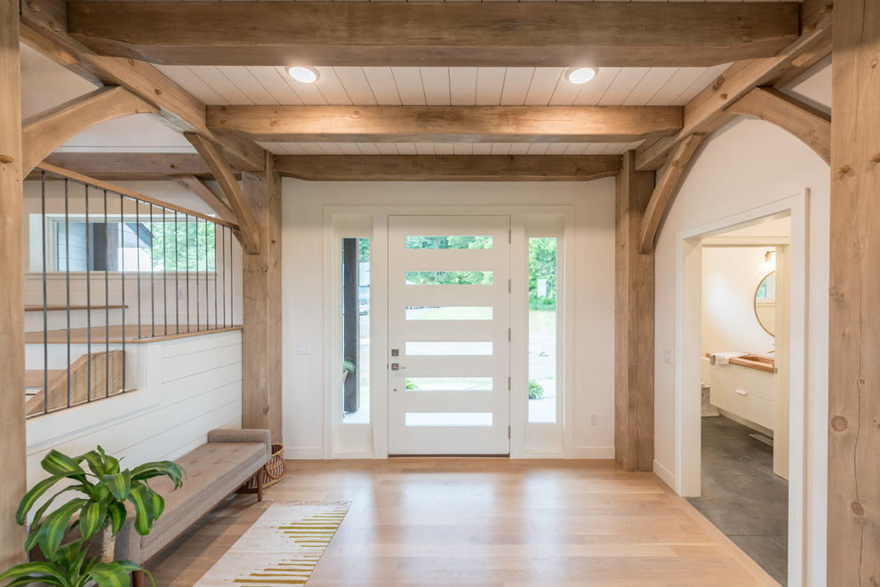 Modelo de hall rural de tamaño medio con paredes blancas, suelo de madera clara, puerta simple, puerta de vidrio y suelo marrón