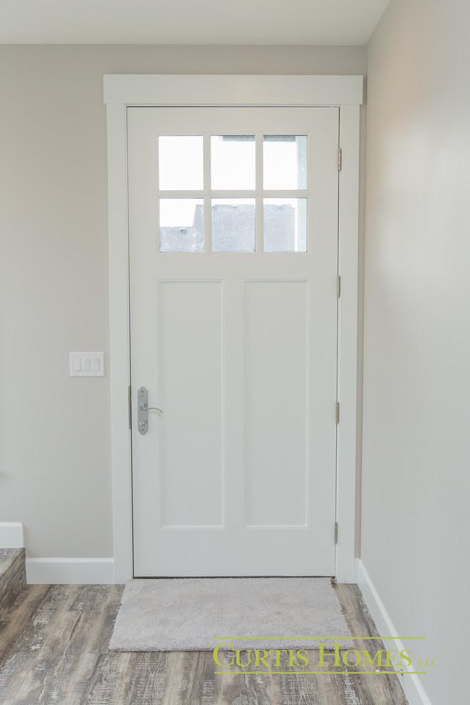Kleine Landhausstil Haustür mit grauer Wandfarbe, hellem Holzboden, Einzeltür und weißer Haustür in Portland