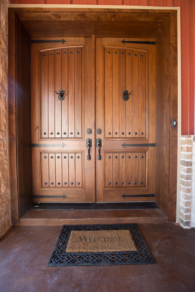 Пример оригинального дизайна: входная дверь среднего размера в стиле рустика с красными стенами, двустворчатой входной дверью и входной дверью из дерева среднего тона