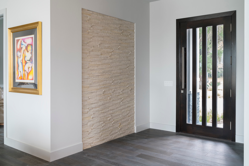 Foto de entrada minimalista con paredes grises, suelo de madera oscura, puerta simple y puerta de madera oscura
