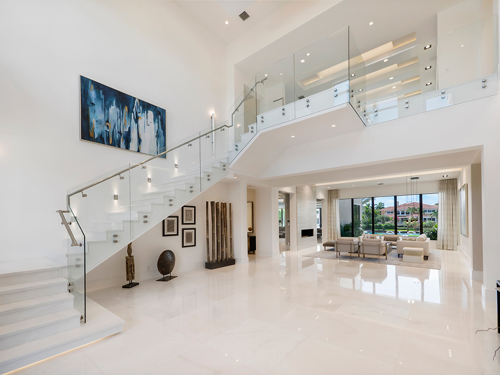 Large contemporary foyer in Miami with white walls and marble flooring.