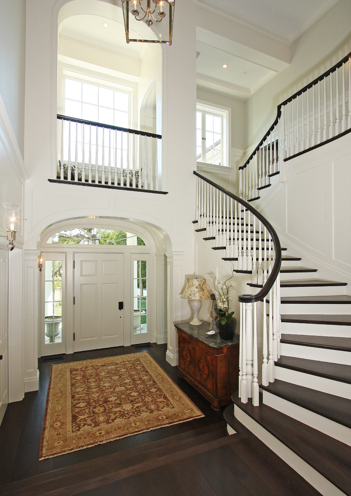 Großes Klassisches Foyer mit weißer Wandfarbe, dunklem Holzboden, Einzeltür und weißer Haustür in Los Angeles