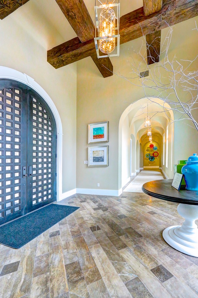 Photo of a large traditional foyer in Austin with beige walls, a double front door, a metal front door and brown floors.