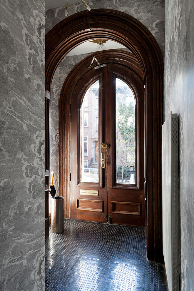 Aménagement d'une entrée contemporaine avec un mur gris, une porte double et une porte en bois foncé.