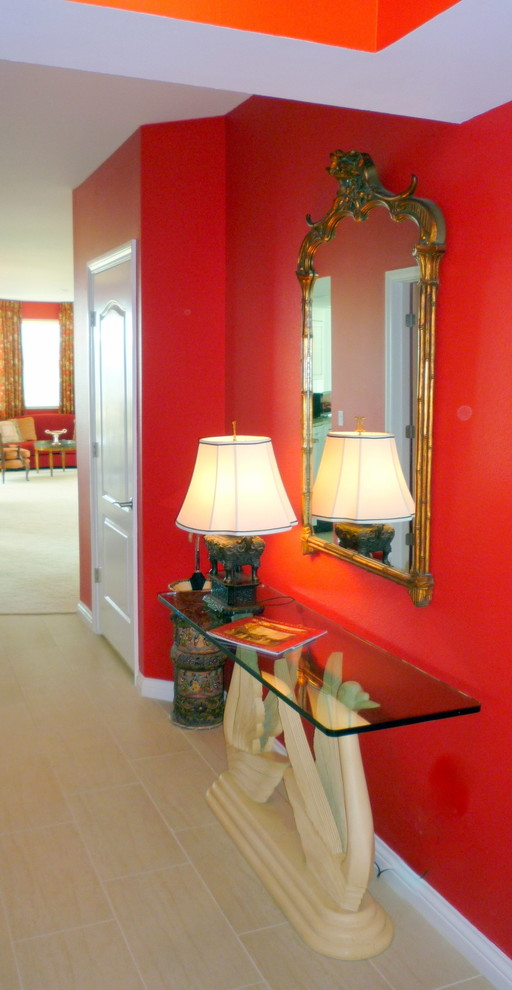 Inredning av en eklektisk mellanstor foajé, med röda väggar, klinkergolv i porslin, en enkeldörr och en vit dörr