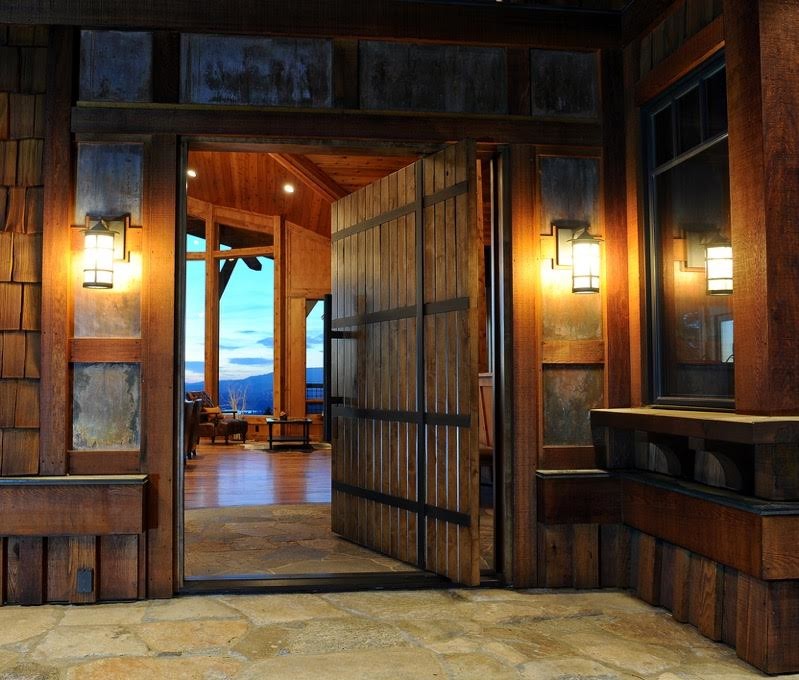 Ispirazione per una porta d'ingresso rustica di medie dimensioni con pareti marroni, una porta a pivot e una porta in legno bruno