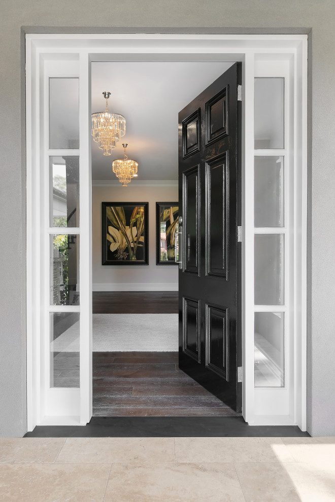 Imagen de puerta principal blanca tradicional grande con paredes blancas, suelo de madera oscura, puerta simple, puerta negra y suelo marrón