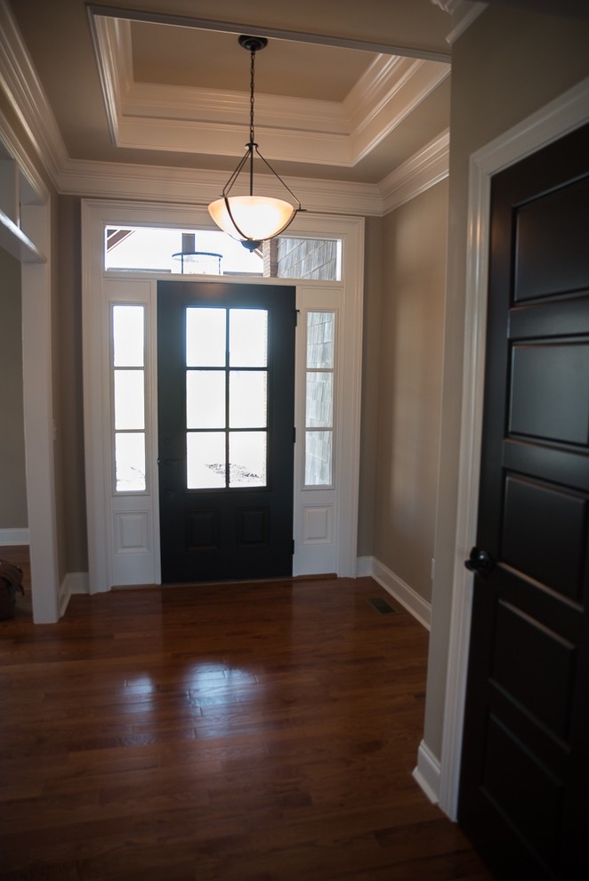 Exemple d'une grande porte d'entrée craftsman avec un mur gris, sol en béton ciré, une porte simple et une porte grise.