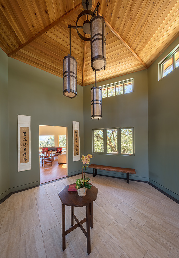 Ispirazione per un ingresso minimal di medie dimensioni con pareti verdi, pavimento in gres porcellanato, una porta singola, una porta in legno bruno e pavimento beige