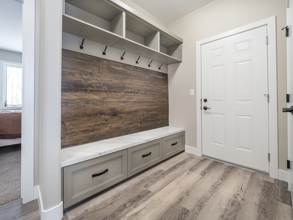 This is an example of a large contemporary boot room in Edmonton with beige walls, vinyl flooring, a single front door, a white front door and multi-coloured floors.