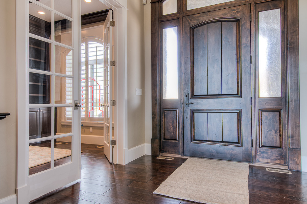 Diseño de puerta principal tradicional de tamaño medio con paredes grises, suelo de madera oscura y puerta de madera oscura