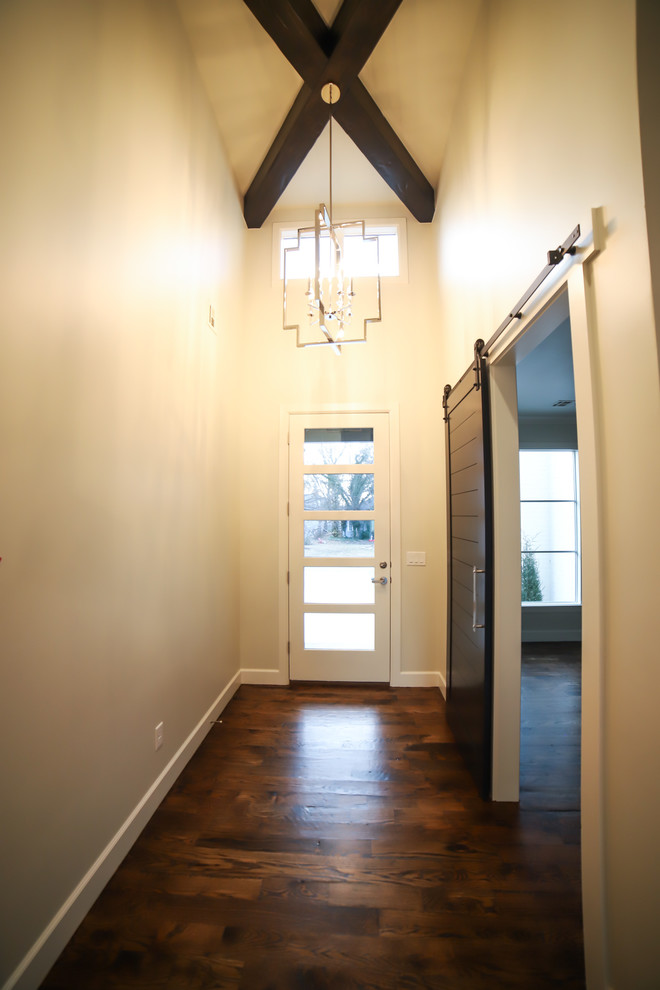 他の地域にあるラグジュアリーな中くらいなカントリー風のおしゃれな玄関ホール (グレーの壁、濃色無垢フローリング、白いドア、茶色い床) の写真
