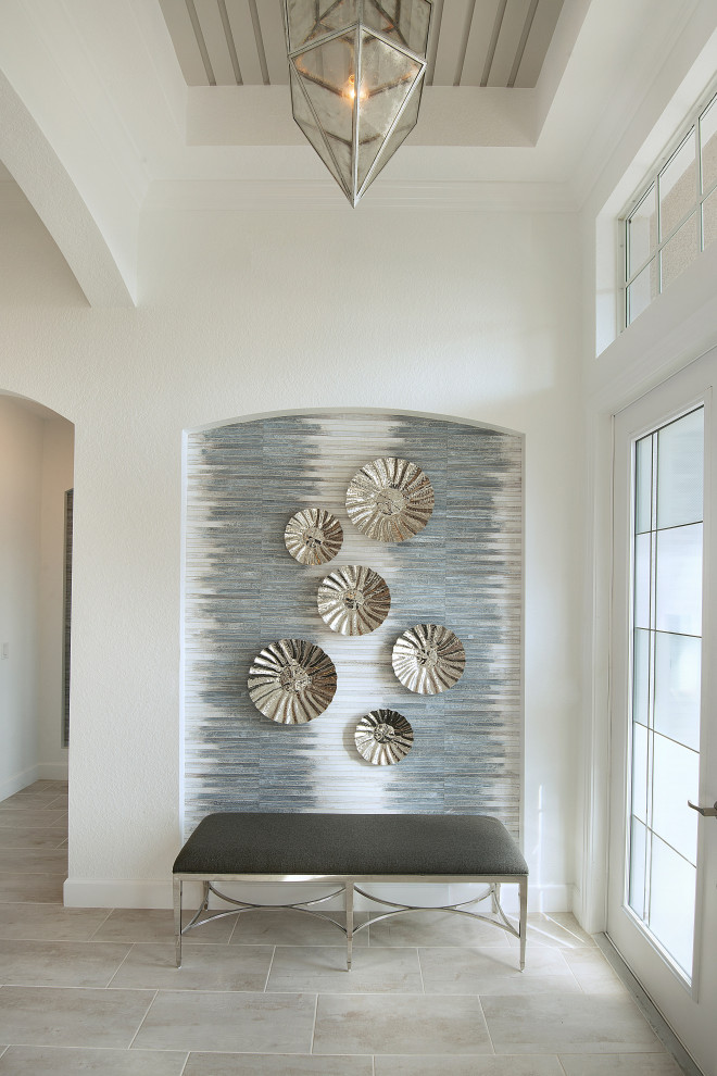 Idée de décoration pour un hall d'entrée marin de taille moyenne avec un mur blanc, un sol en carrelage de céramique, une porte simple, une porte en verre et un sol gris.