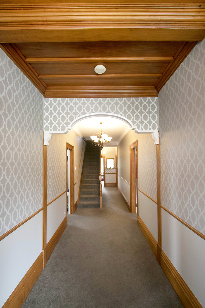 Ispirazione per un corridoio tradizionale di medie dimensioni con pareti grigie, moquette, una porta singola, una porta bianca e pavimento grigio