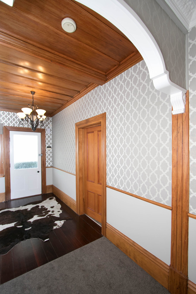 Mittelgroßer Klassischer Eingang mit Korridor, grauer Wandfarbe, dunklem Holzboden, Einzeltür, weißer Haustür und grauem Boden in Wellington