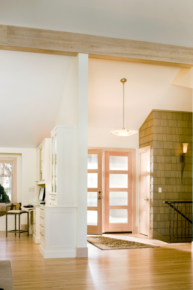 Пример оригинального дизайна: огромное фойе в стиле неоклассика (современная классика) с белыми стенами, светлым паркетным полом, двустворчатой входной дверью и входной дверью из светлого дерева