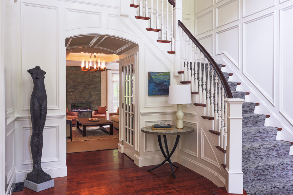 Example of a large classic dark wood floor and brown floor foyer design in Boston with white walls