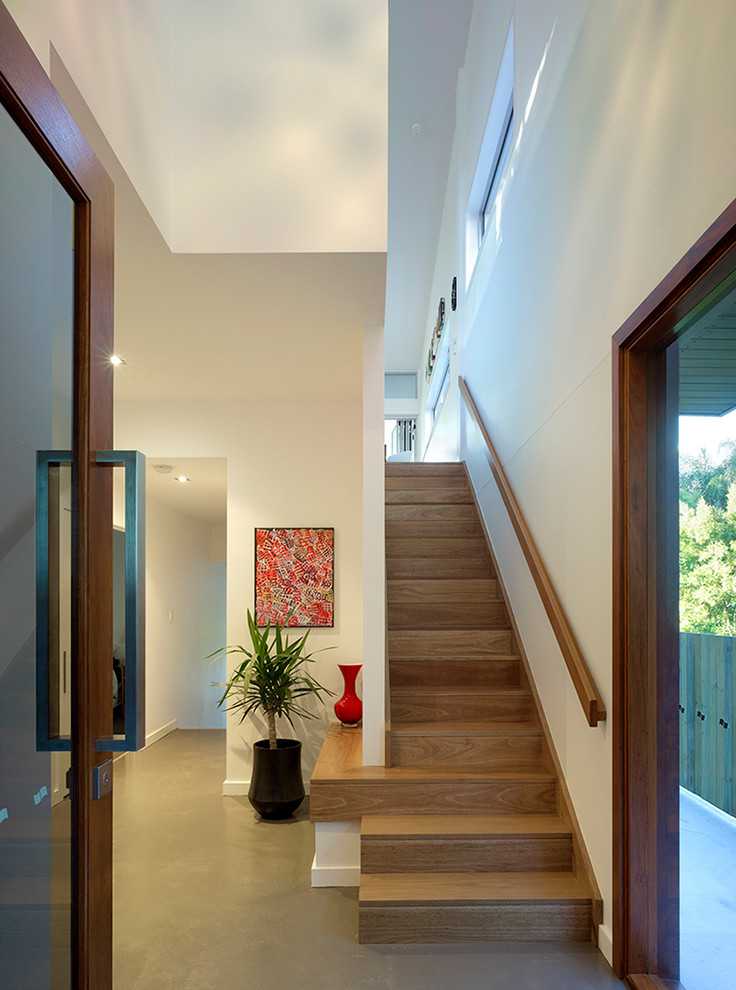 Foyer - contemporary concrete floor foyer idea in Brisbane with white walls and a medium wood front door