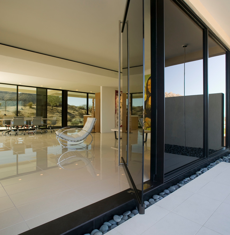 Ispirazione per un ingresso o corridoio minimalista con una porta a pivot e pavimento bianco
