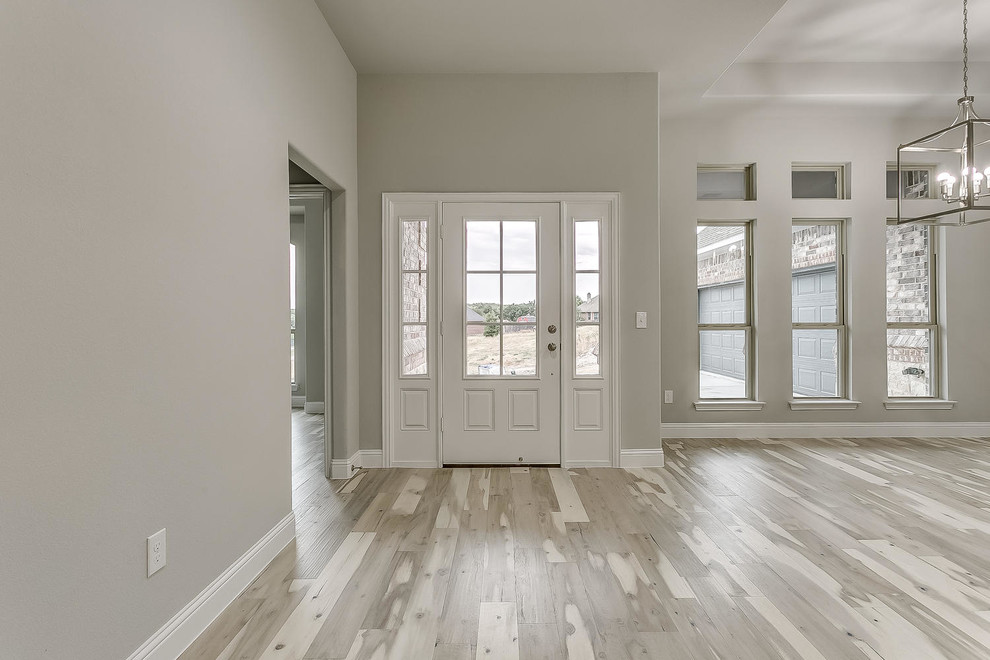 Foto de puerta principal minimalista de tamaño medio con paredes grises, suelo de madera clara, puerta simple, puerta gris y suelo marrón