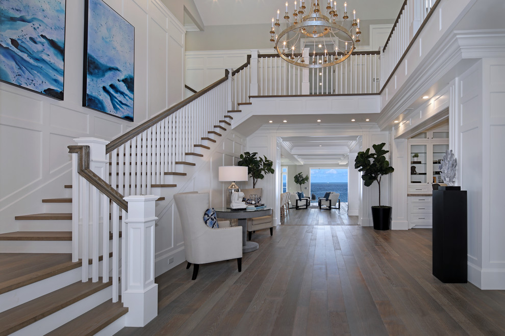 Nautical foyer in Orange County with white walls, medium hardwood flooring and feature lighting.