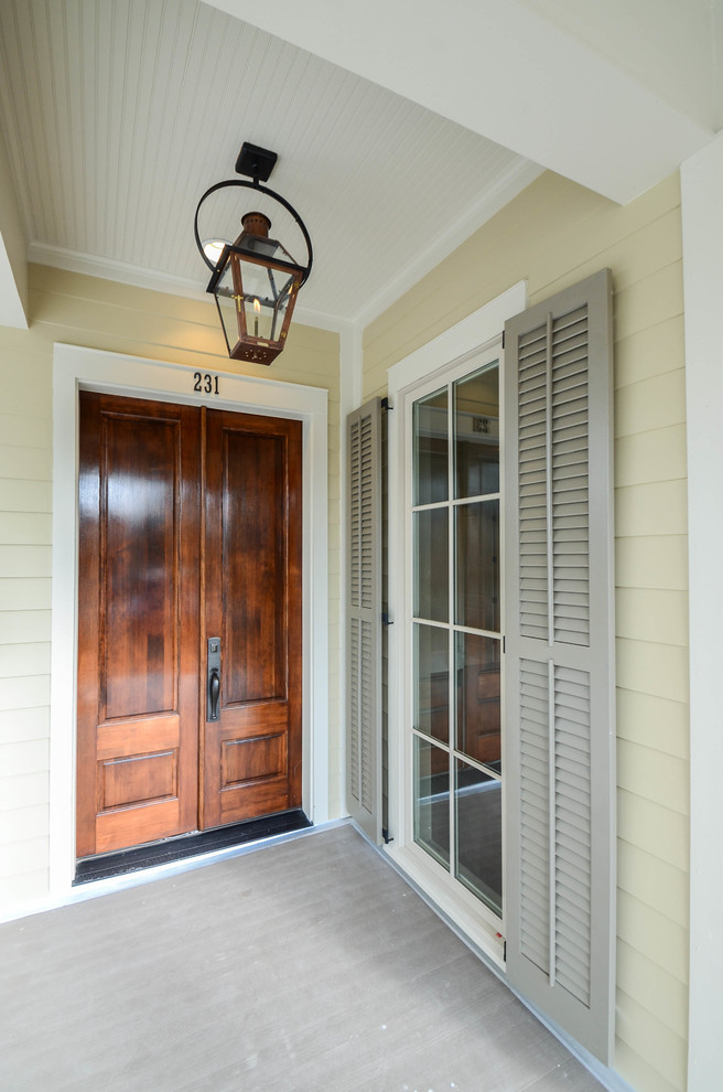 Idee per una porta d'ingresso classica di medie dimensioni con pareti beige, una porta a due ante e una porta in legno bruno