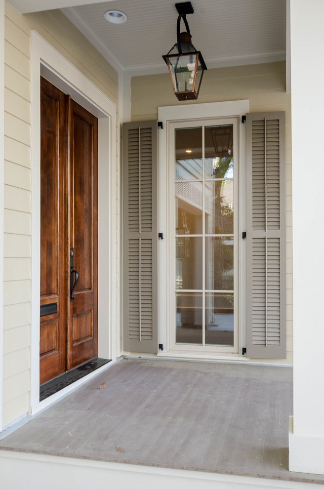 Medium sized traditional front door in New Orleans with beige walls, a double front door and a medium wood front door.