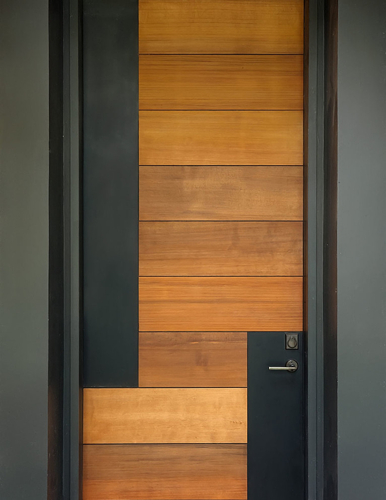 Ispirazione per una grande porta d'ingresso contemporanea con pareti nere, una porta singola e una porta in legno chiaro