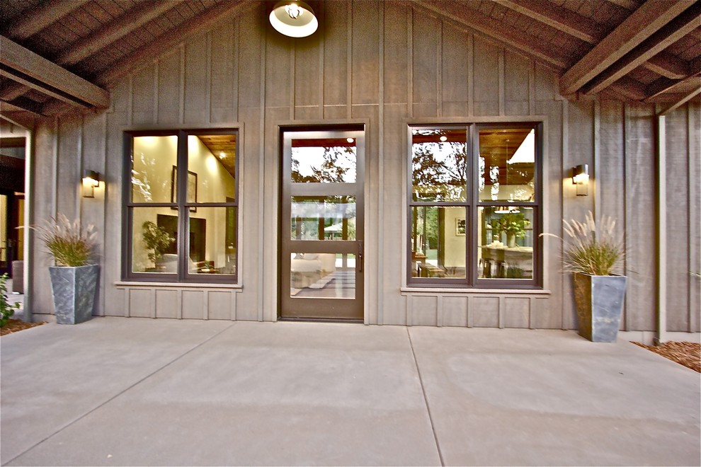 Стильный дизайн: входная дверь среднего размера в стиле кантри с коричневыми стенами, бетонным полом, поворотной входной дверью и коричневой входной дверью - последний тренд