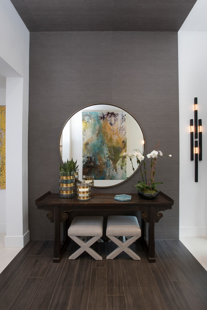 This is an example of a contemporary foyer in Miami with grey walls, dark hardwood flooring, brown floors and a feature wall.