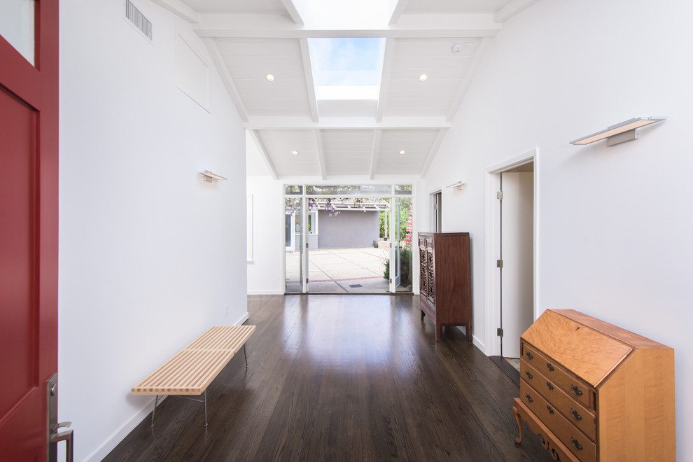 This is an example of an expansive traditional foyer in Los Angeles with white walls, dark hardwood flooring and brown floors.
