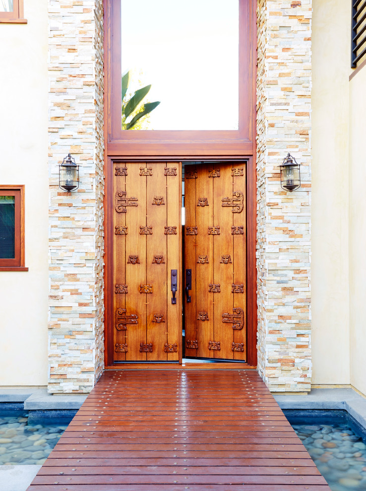Imagen de puerta principal contemporánea grande con puerta doble, paredes blancas, suelo de madera oscura, puerta de madera en tonos medios y suelo marrón