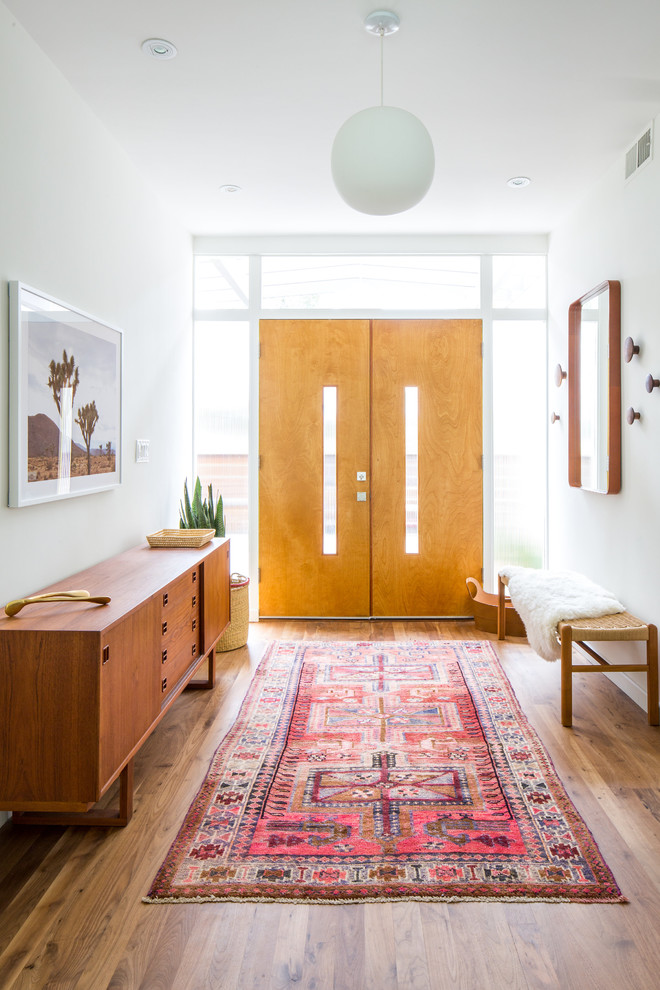 Imagen de entrada retro con paredes blancas, suelo de madera en tonos medios, puerta doble, puerta de madera en tonos medios y suelo marrón
