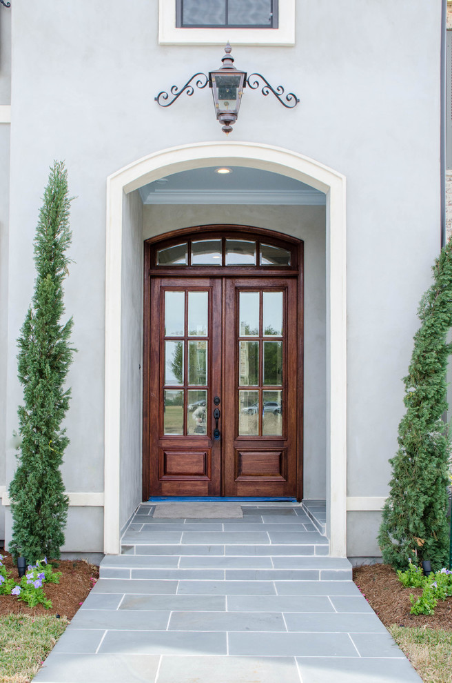 Idée de décoration pour une porte d'entrée tradition de taille moyenne avec un mur gris, une porte double et une porte en bois foncé.