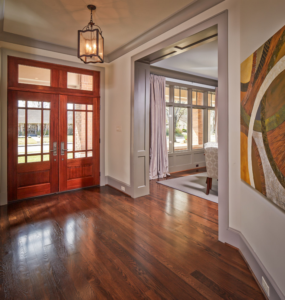 Ispirazione per un ingresso tradizionale di medie dimensioni con una porta a due ante, pareti bianche, pavimento in legno massello medio e una porta in legno bruno