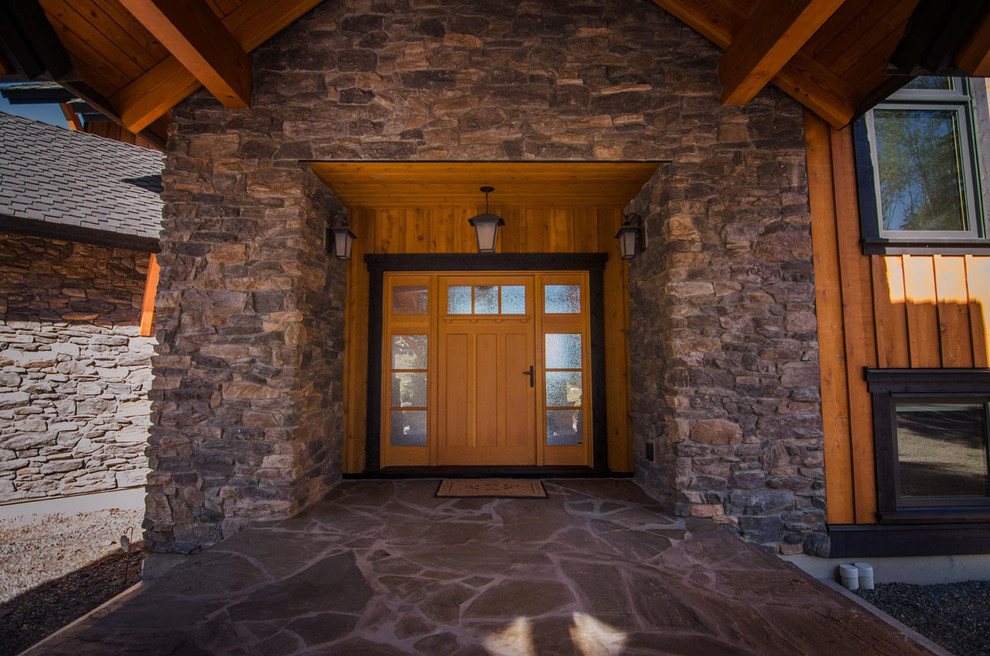 Idee per una grande porta d'ingresso stile rurale con pareti multicolore, pavimento in pietra calcarea, una porta singola, una porta in legno bruno e pavimento marrone