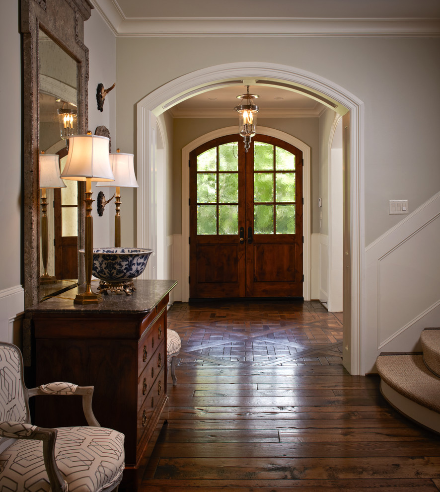 Photo of a medium sized traditional foyer in Houston with a dark wood front door, grey walls, brown floors, dark hardwood flooring, a double front door and feature lighting.