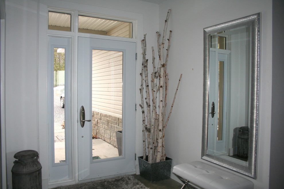 Foto på en mellanstor eklektisk foajé, med vita väggar, betonggolv, en enkeldörr, en vit dörr och grått golv