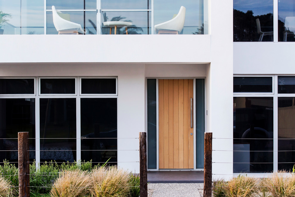 Moderner Eingang mit weißer Wandfarbe, Porzellan-Bodenfliesen, Drehtür und heller Holzhaustür in Adelaide
