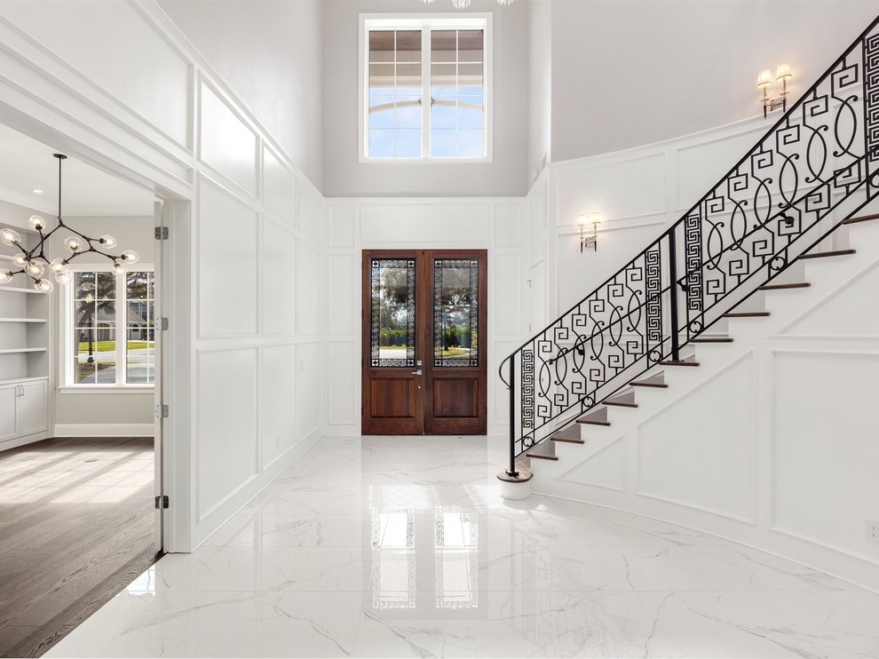 Example of a large transitional marble floor and white floor entryway design in Orlando with beige walls and a dark wood front door