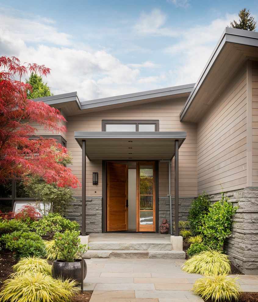 This is an example of a contemporary front door in Seattle with a single front door and a medium wood front door.