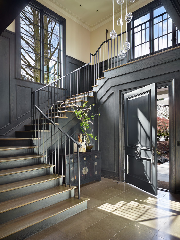 На фото: большое фойе в стиле неоклассика (современная классика) с коричневыми стенами, одностворчатой входной дверью и бежевым полом