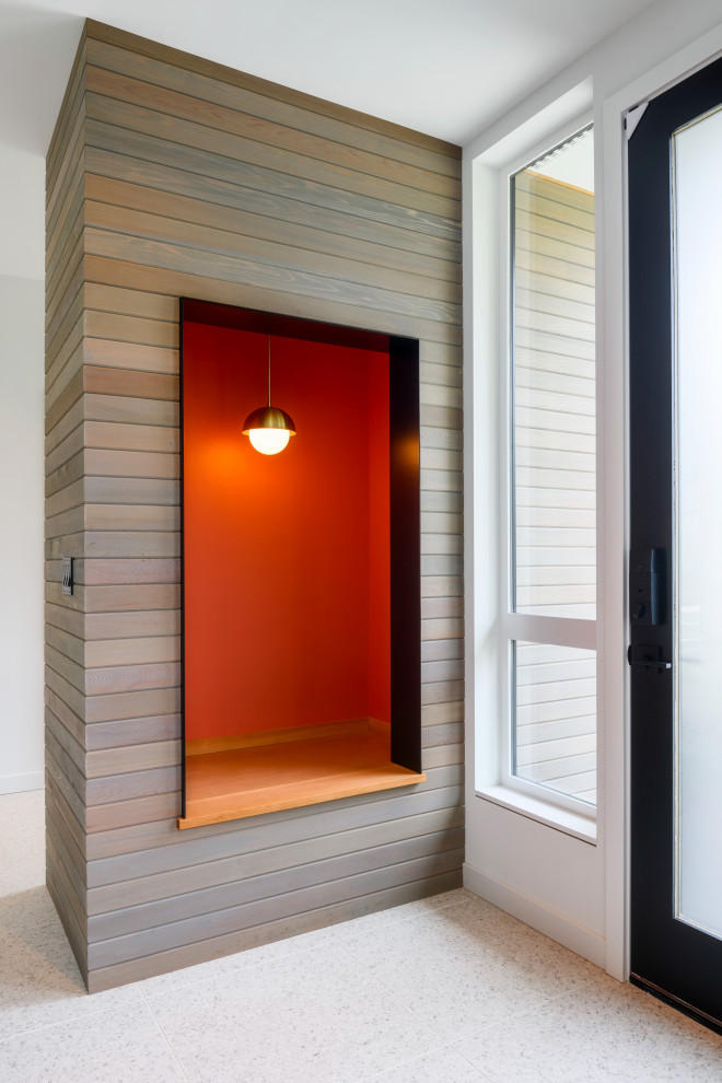 На фото: фойе среднего размера в стиле модернизм с белыми стенами, полом из терраццо, одностворчатой входной дверью, стеклянной входной дверью, белым полом и стенами из вагонки с